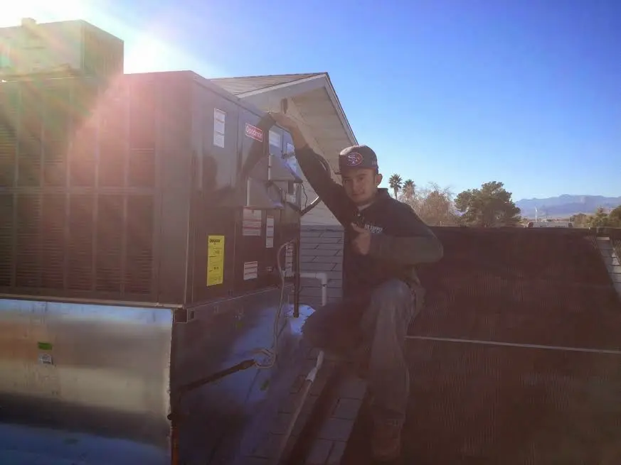 HVAC technician performing HVAC Inspection on a rooftop unit in Montvale